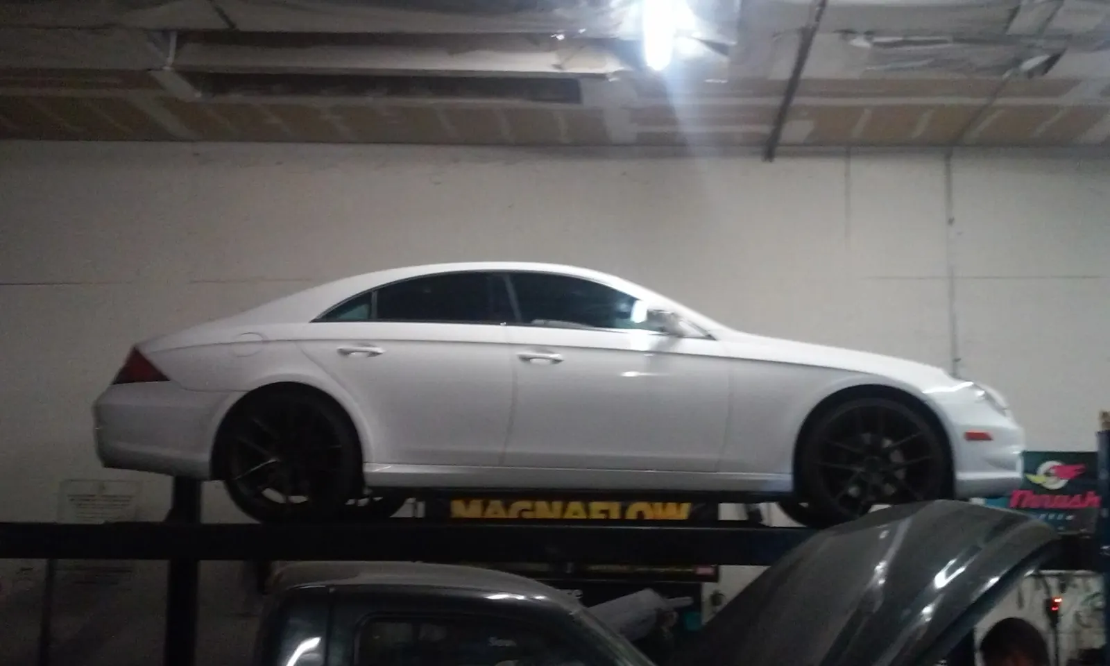 White Mercedes CLS on the lift during service