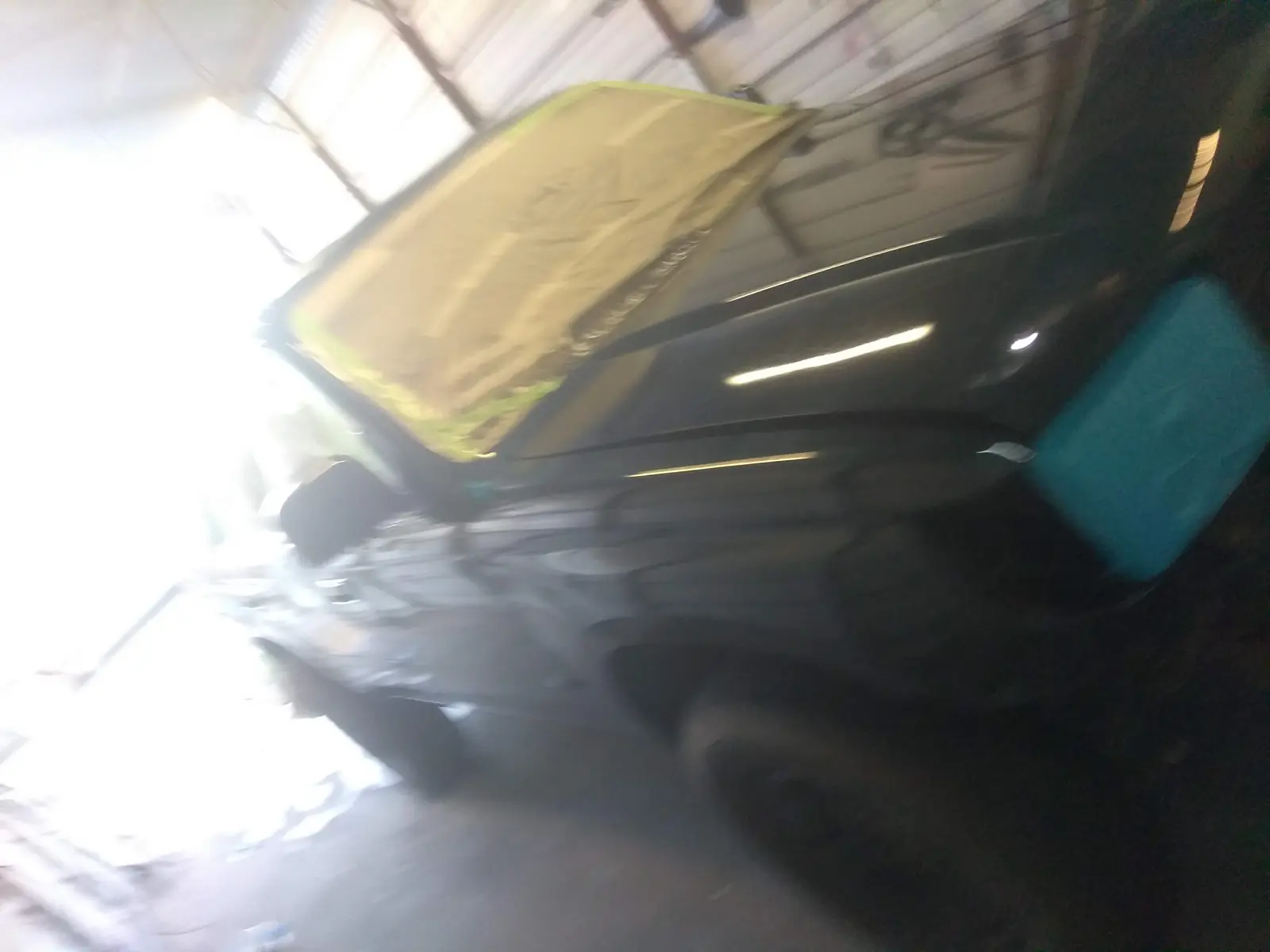 Dark sedan with the hood up during service