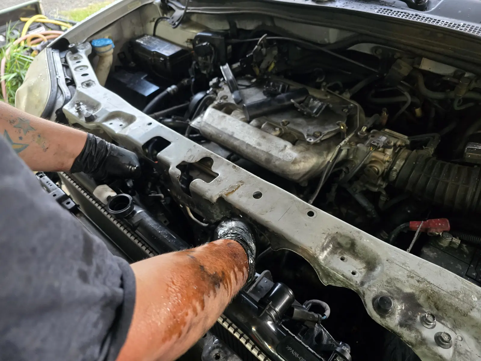 Silver sedan with the hood up, engine bay service