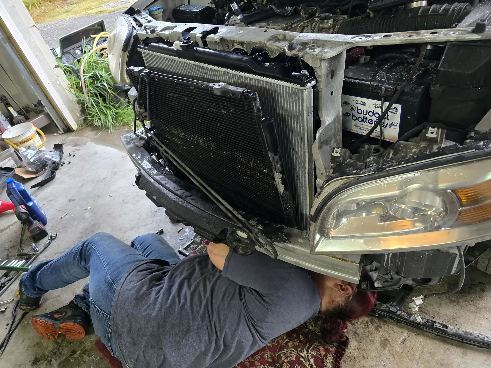 Silver vehicle with the front clip off, radiator replacement